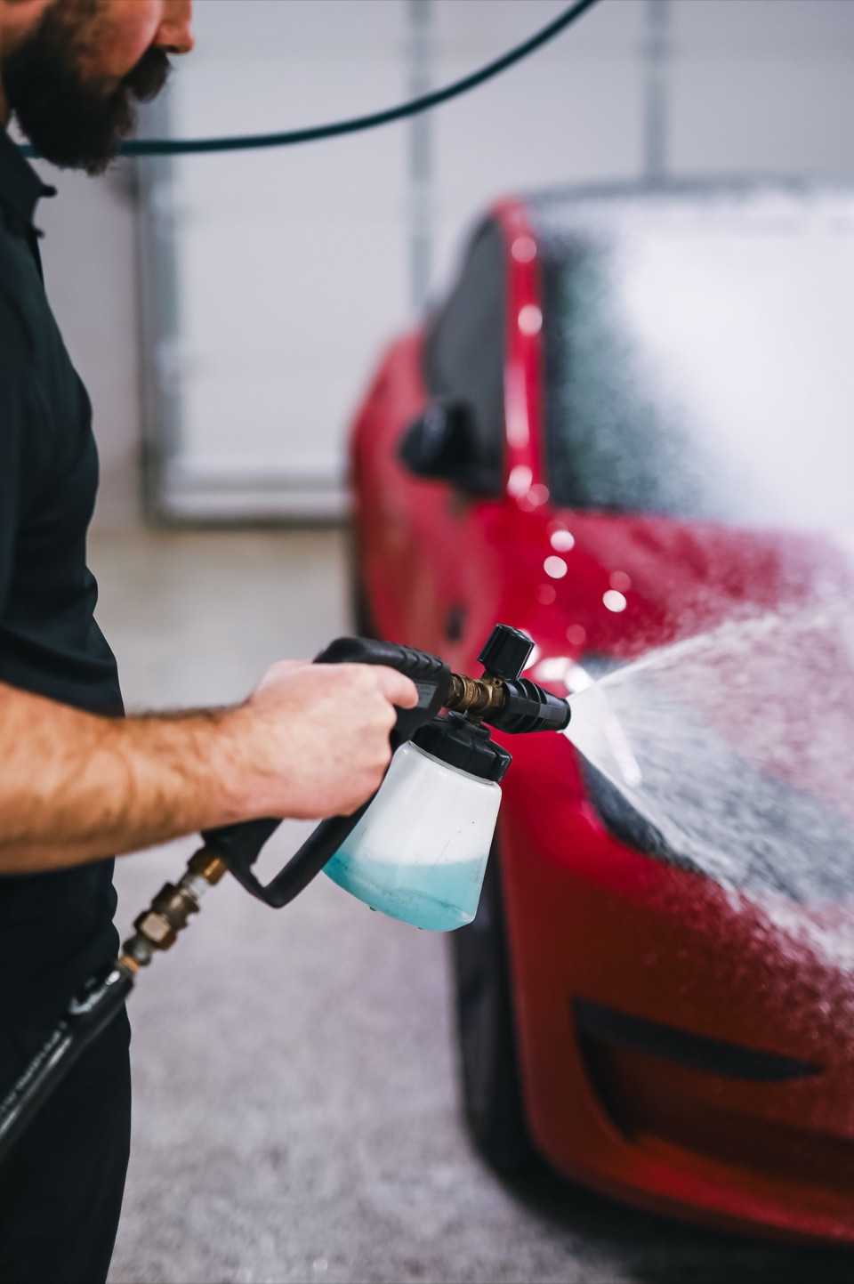 Snow foam on a red car before a hand wash