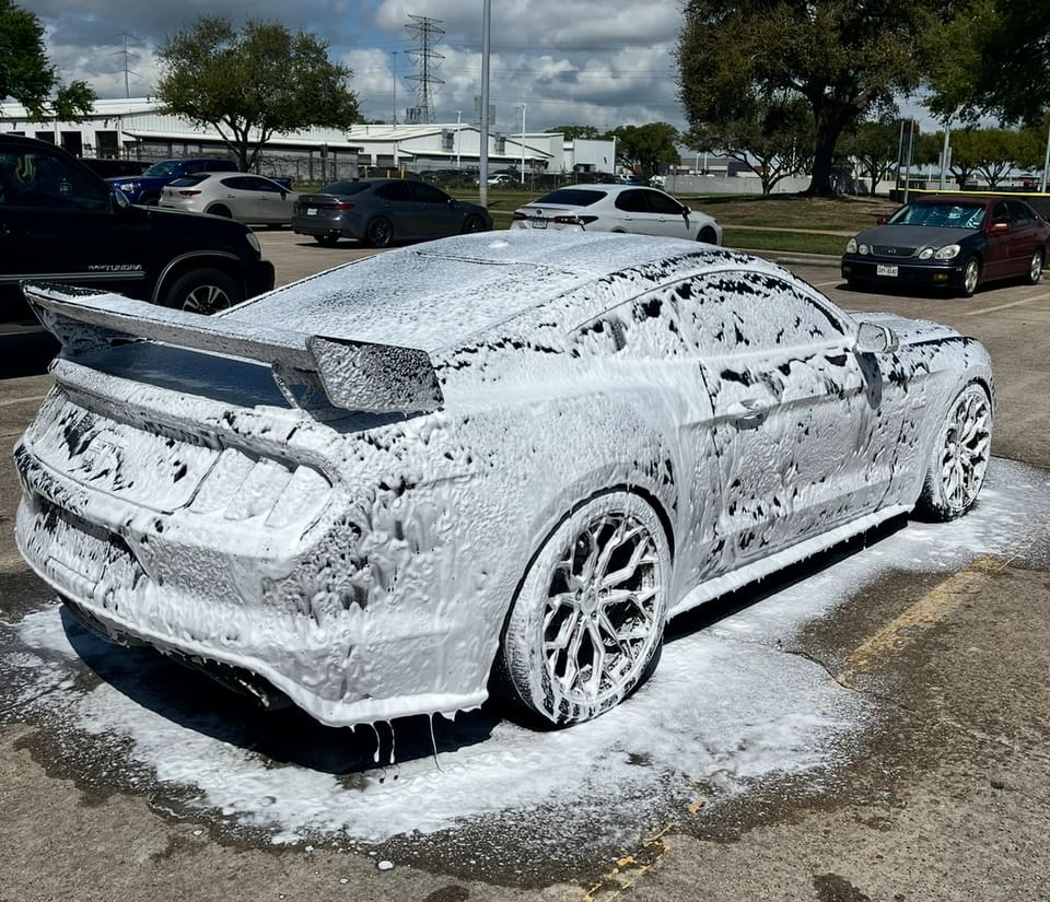 Dodge Charger under snow foam before a hand wash