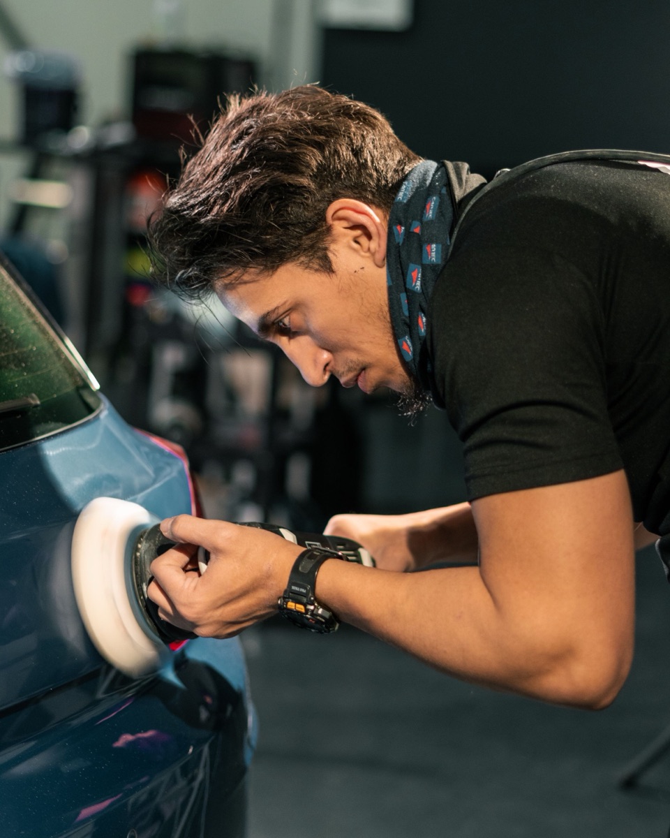 Detailer concentrating on a machine polish